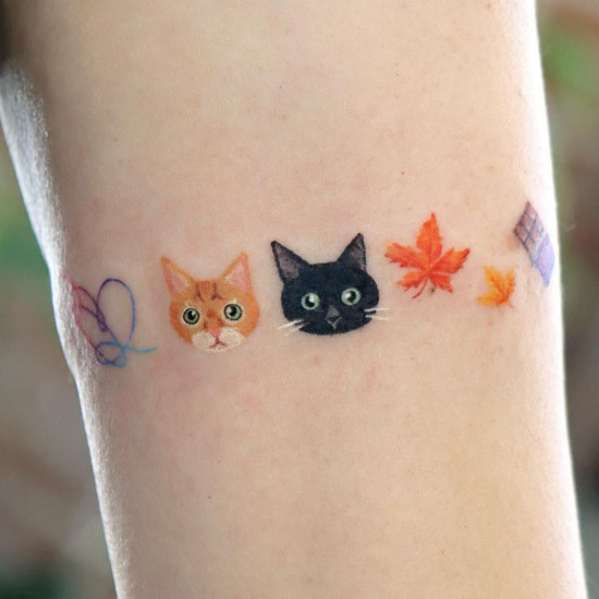 A row of colorful small cat tattoo elements including cat faces, autumn leaves and a heart-shaped yarn ball.