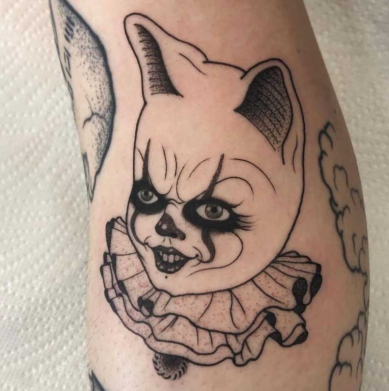 Pennywise cat hybrid tattoo, a horror twist on a cute concept, collected by Georgie.