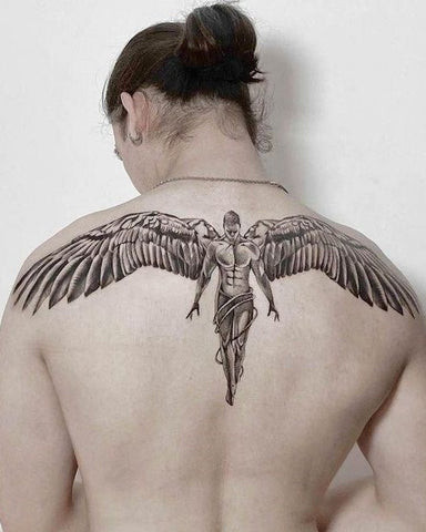 Sharp upper back tattoo for men featuring stylized wings extending across the shoulder blades, emphasizing muscularity.