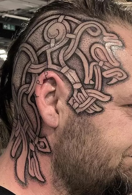 Viking Mammen style head tattoo with intricate animalistic and ornamental designs in black ink.