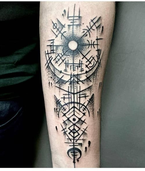 Viking tribal tattoo on a man's arm, showcasing Norse mythology inspired figures and tribal patterns.