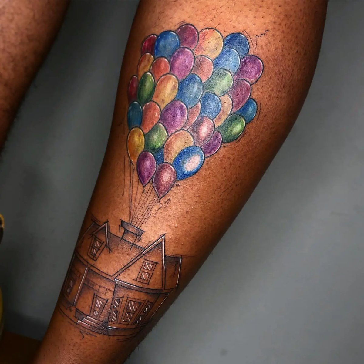 Leg Tattoo on Dark Skin Using Red, Blue and Green Ink