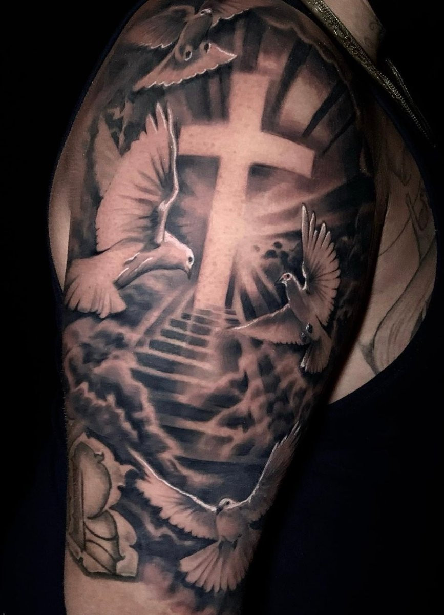 Cross shoulder tattoo design for men with subtle details