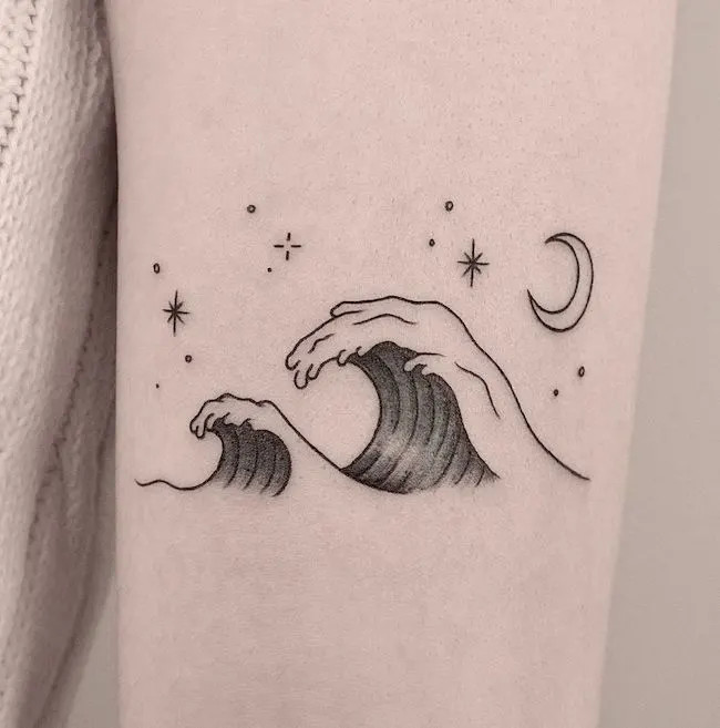 alt text: Minimalist wave tattoo on ankle in black ink, symbolizing transformation, hidden power, and strength in the face of life's currents