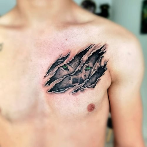 A wolf scratch tattoo on a man's forearm, depicting realistic claw marks with red ink, symbolizing a fighting spirit and the hidden, inner wolf.