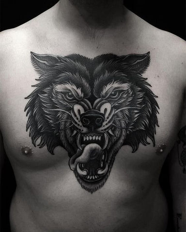 Wolf chest tattoo with intense eyes, symbolizing loyalty, strength, and courage.