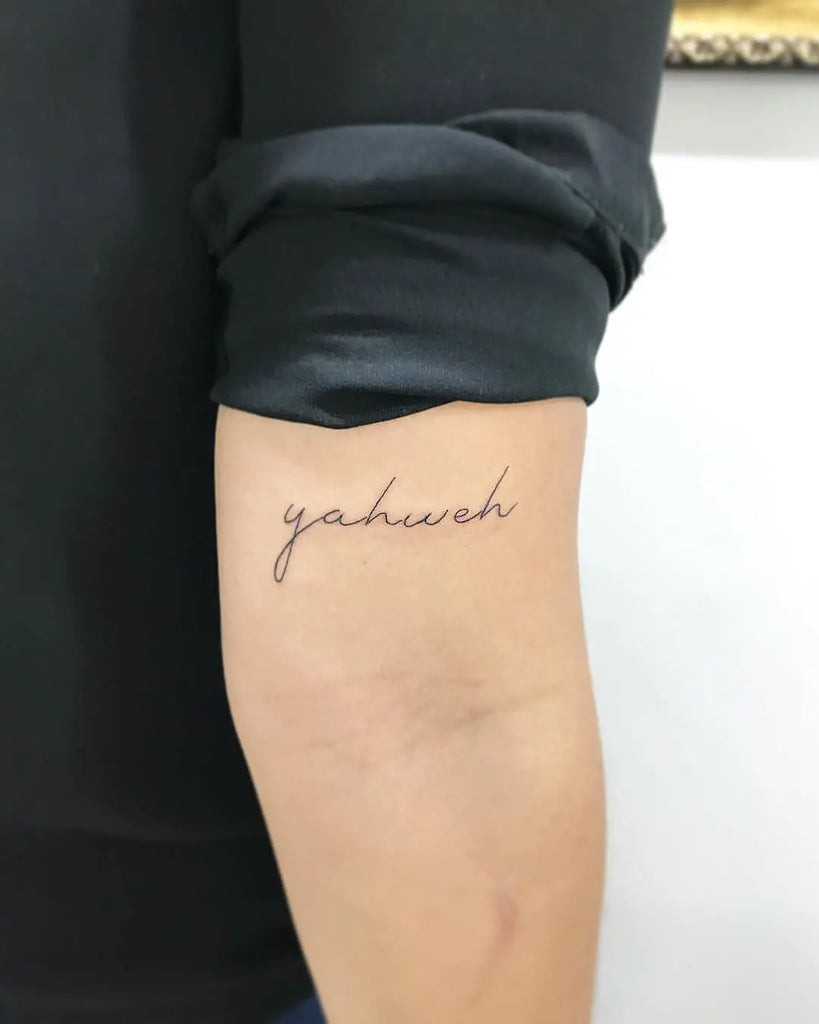 Yahweh Tattoo on the upper back with large, calligraphy-style Hebrew letters