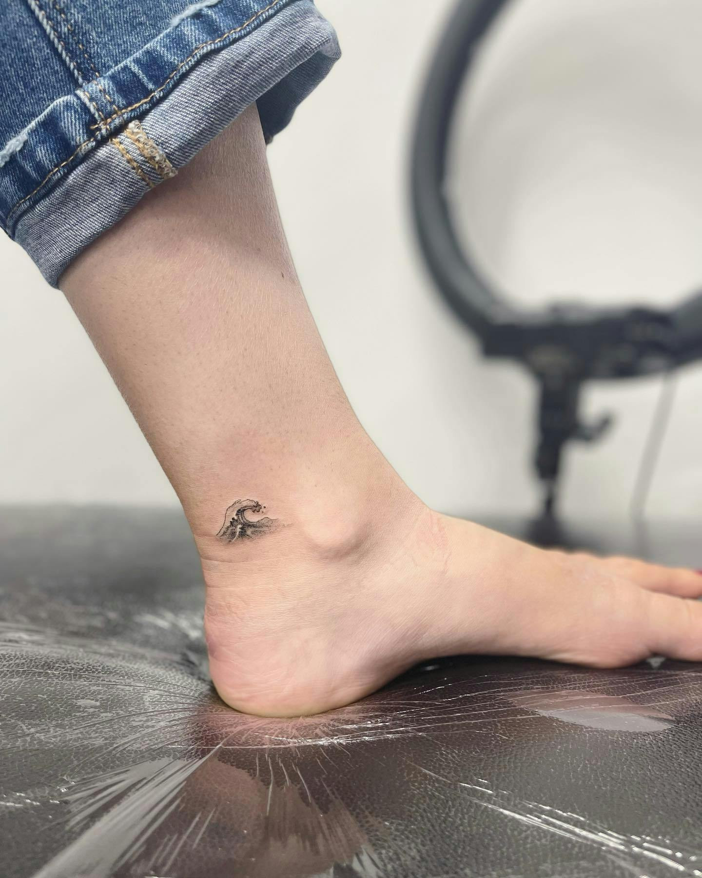 Wave ankle tattoo, shaded wave design on ankle.