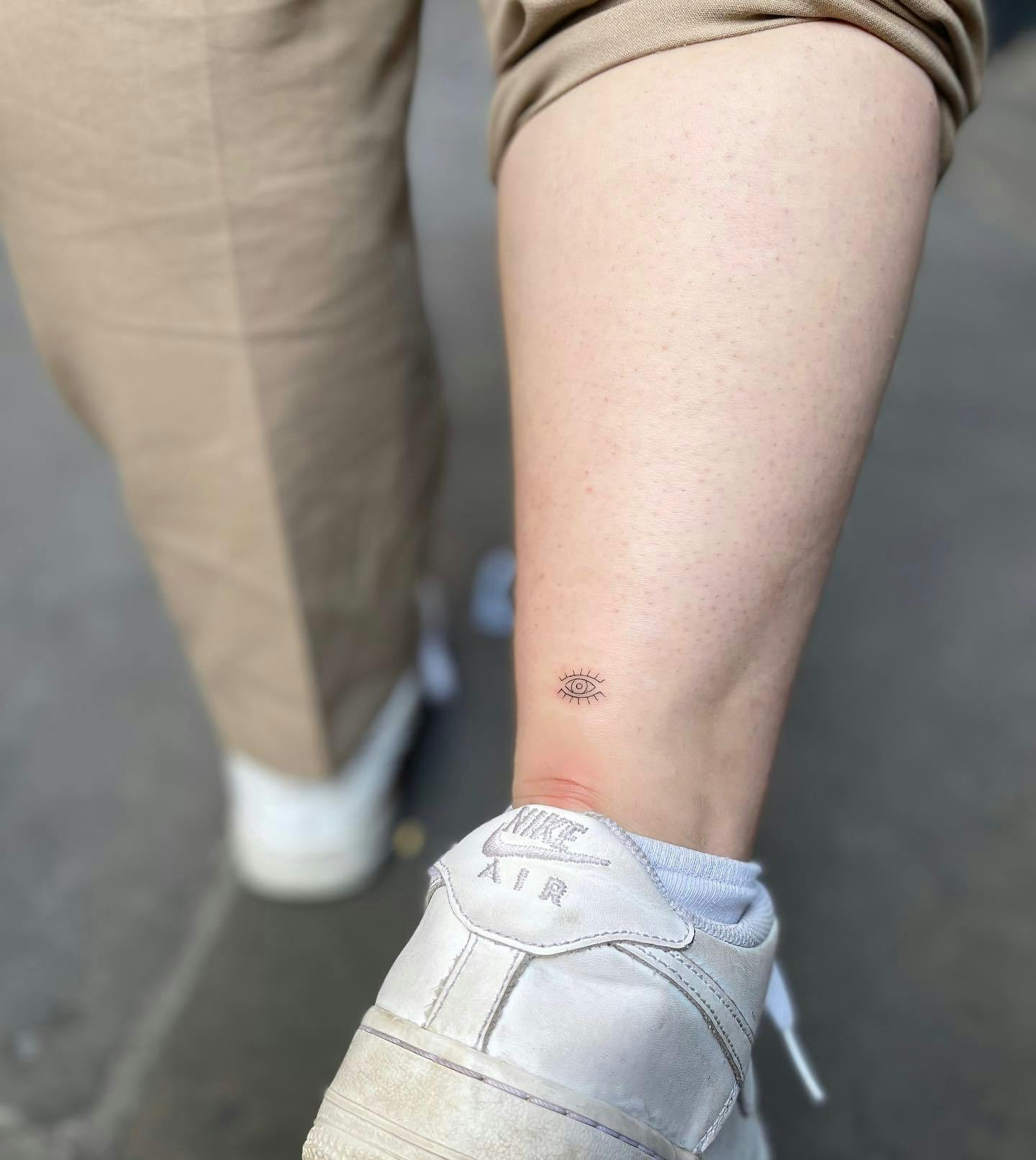 Evil eye ankle tattoo, protective eye symbol on woman's ankle.