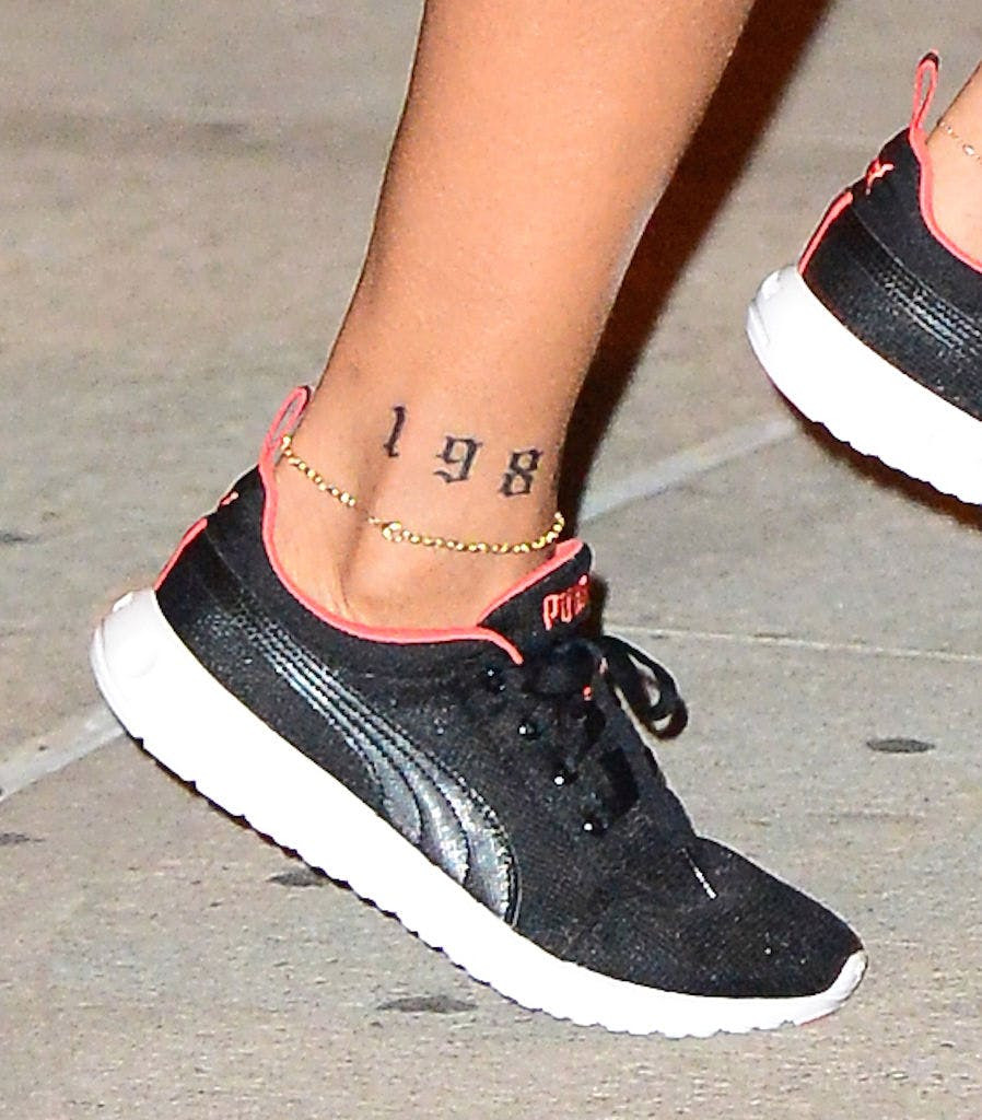 Date ankle tattoo on ankle, gothic script date tattoo on woman.