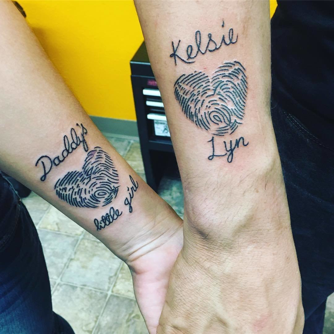 Fingerprint heart tattoos on wrists, showcasing a unique and personal father-daughter bond.