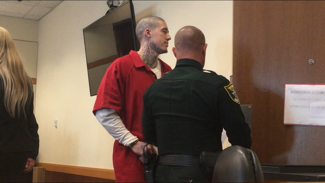 Wade Wilson appearing in Lee County court in 2019, visibly displaying a swastika tattoo on his head, a symbol of hate and extremism.