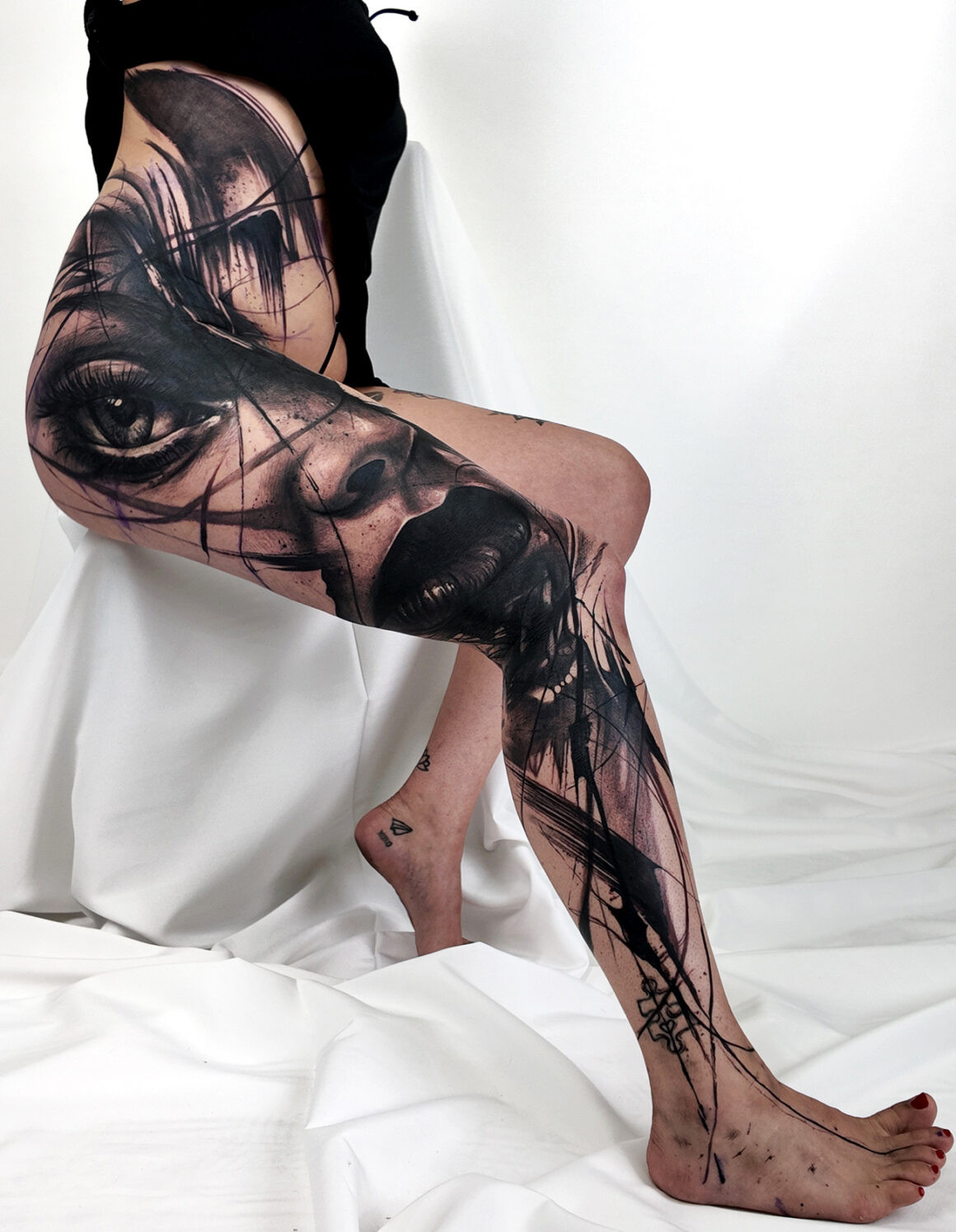 Abstract tattoo on leg by Natalie Nox, featuring dynamic ink flow and artistic expression