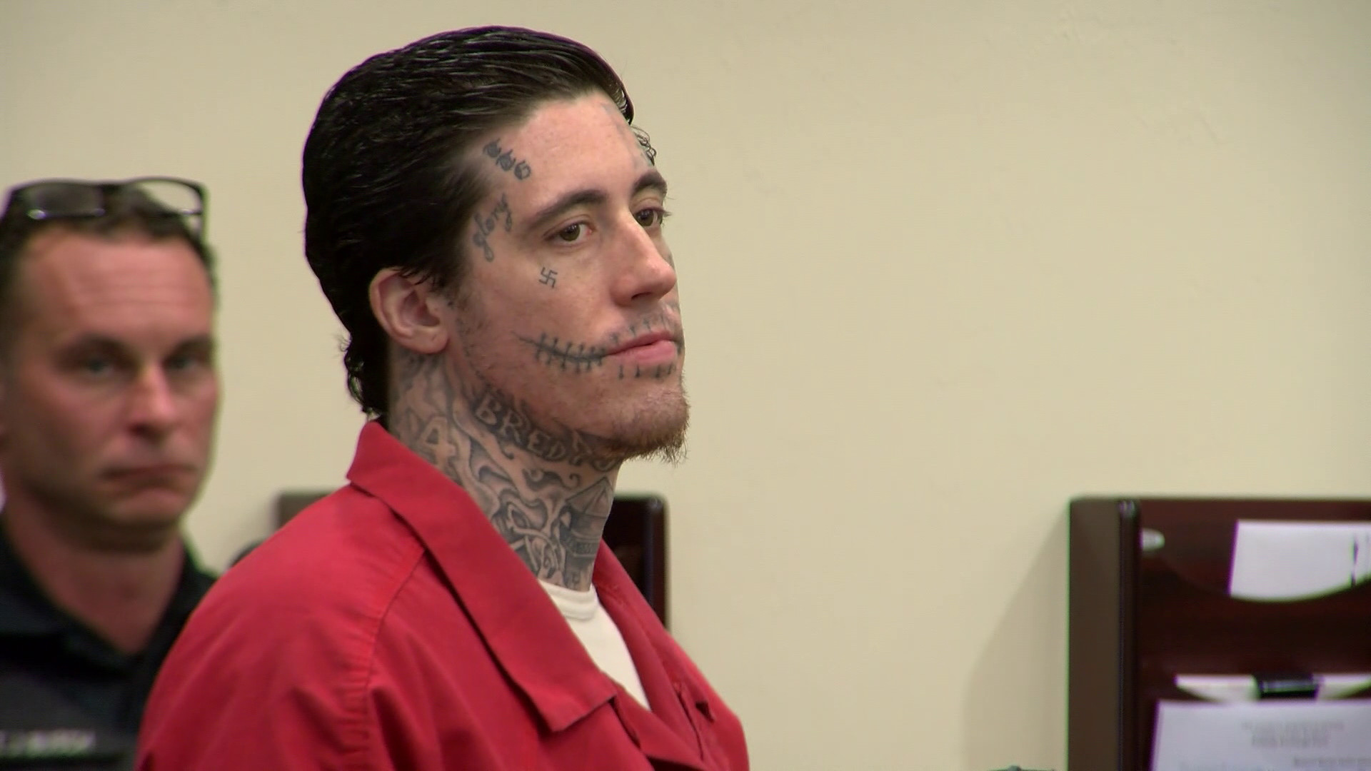 Wade Wilson in court in 2024, showcasing new face tattoos including a smaller swastika under his eye, stitches by his mouth, and the word &quot;glory&quot; on his temple.