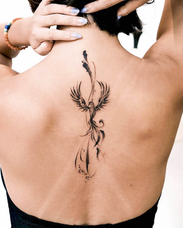 Powerful spine tattoo of a black phoenix, designed by @tattooist_jaymee