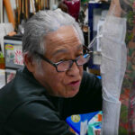 Close-up of Horiyoshi wrapping the ribs of a client, showcasing the intricate details of the tattoo