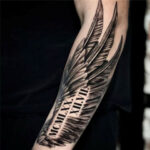 Roman numeral feather tattoo featuring intricate line work and shading