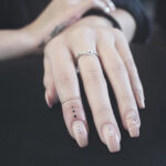 Three Dot Tattoo on Finger Representing an Unfinished Journey