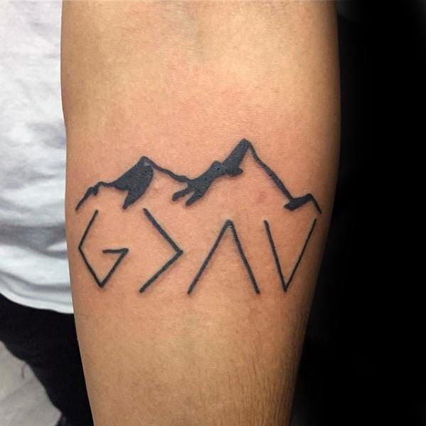 A hand featuring the &quot;God is greater than the highs and lows&quot; symbol tattooed on the finger.