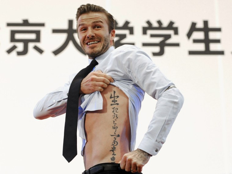 David Beckham displays his tattoos during a visit to Peking University