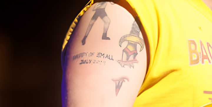 Zach Bryan performing, displaying his &quot;Daddy of em all July 2023&quot; tattoo.
