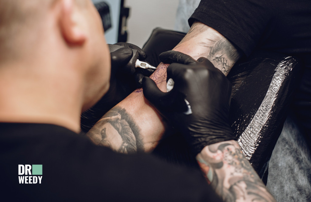 Tattoo artist working on a detailed sleeve tattoo, showcasing precision and artistry