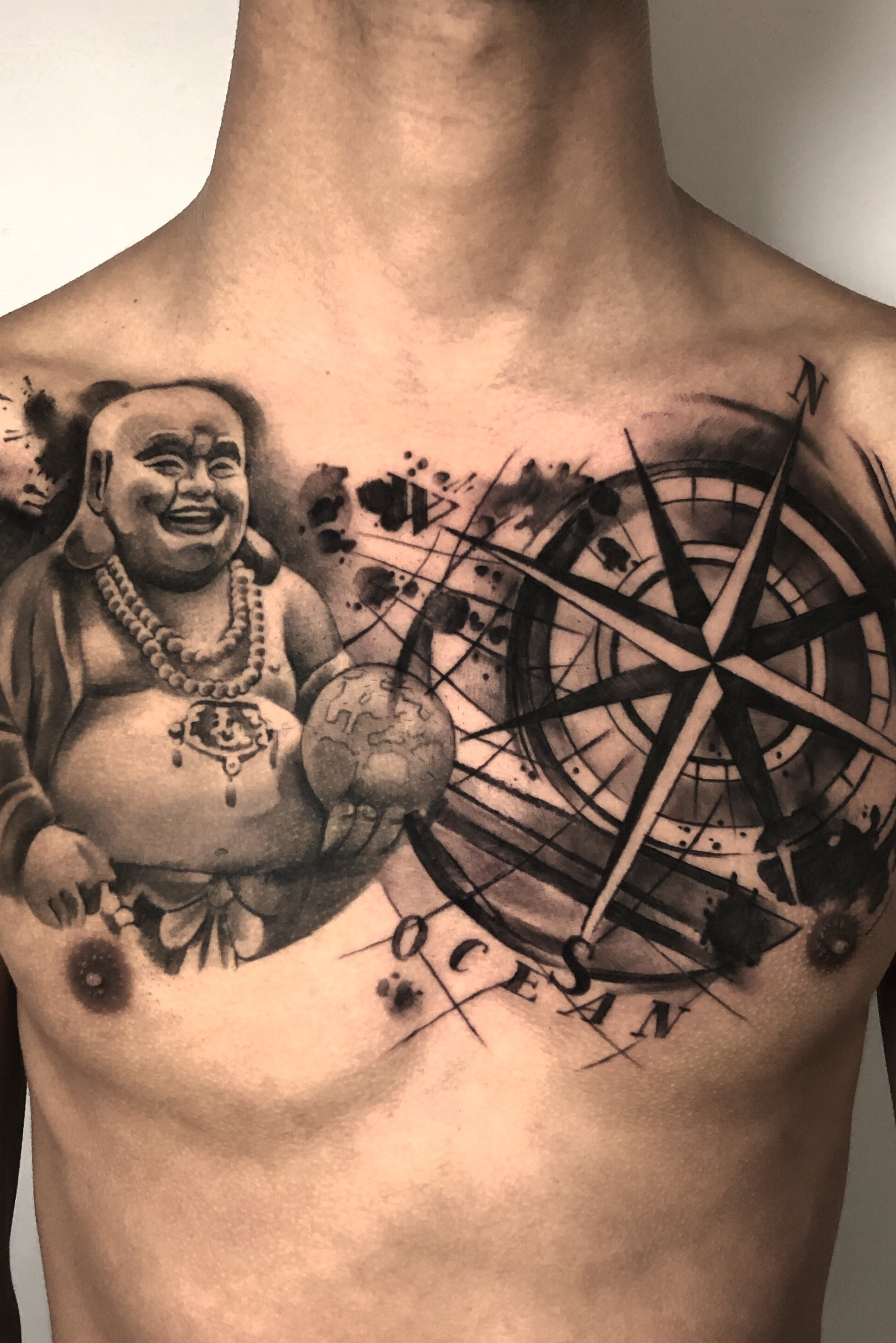 A laughing Buddha chest tattoo