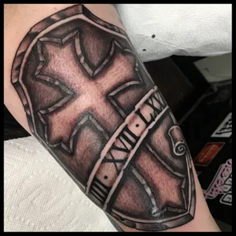 Roman numeral cross tattoo with the date of a significant religious event