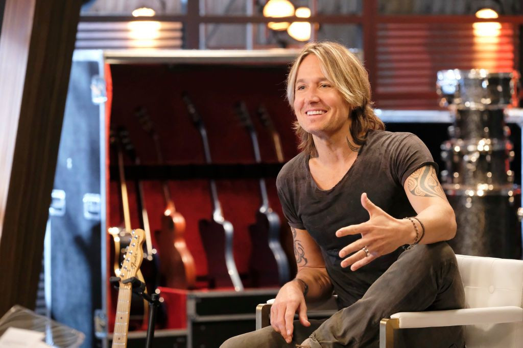 Close-up of Keith Urban's neck, revealing a small, subtle tattoo covered by hair, symbolizing his personal expression.