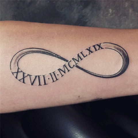 Roman numeral infinity tattoo incorporating a name within the infinity symbol