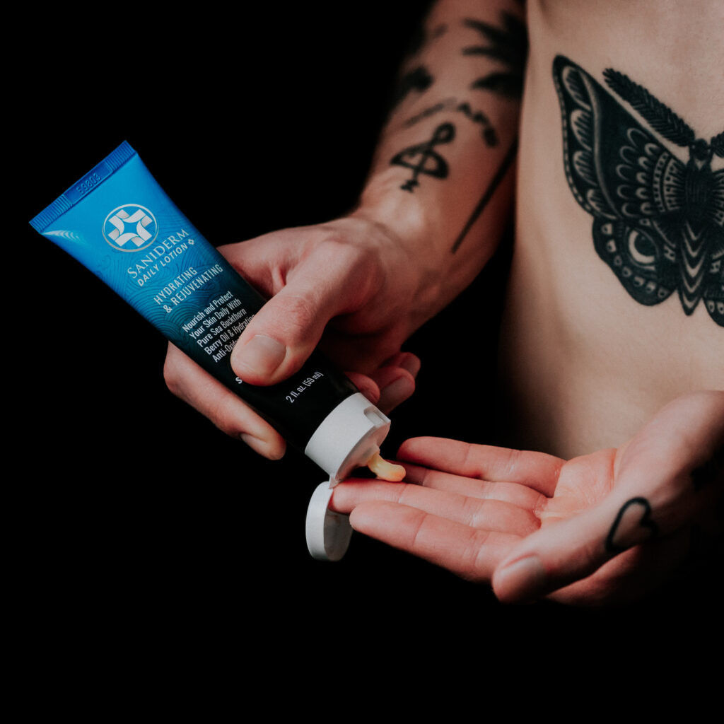 A person moisturizing their tattoo.