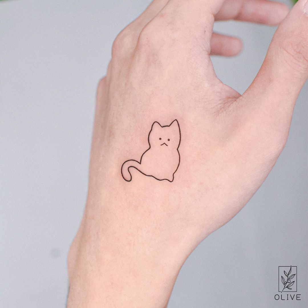 A kitten female hand tattoo that combines cuteness and kittens, paying homage to a beloved pet.