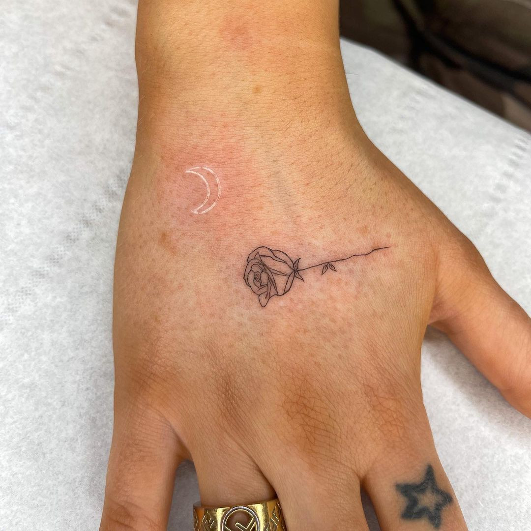 A simple rose tattoo design on a woman's hand, highlighting the classic and timeless appeal of rose tattoos.