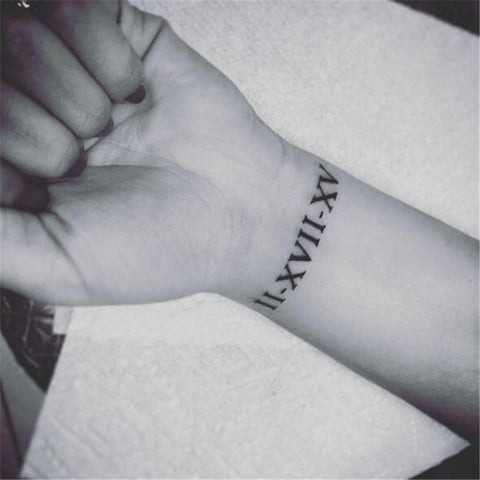 Roman numeral wrist tattoo prominently displayed for constant inspiration