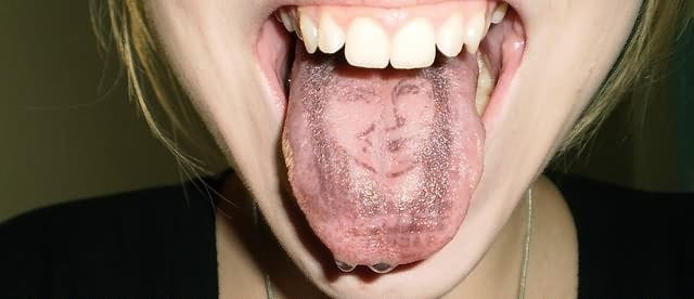 A tongue tattoo with a white ink design