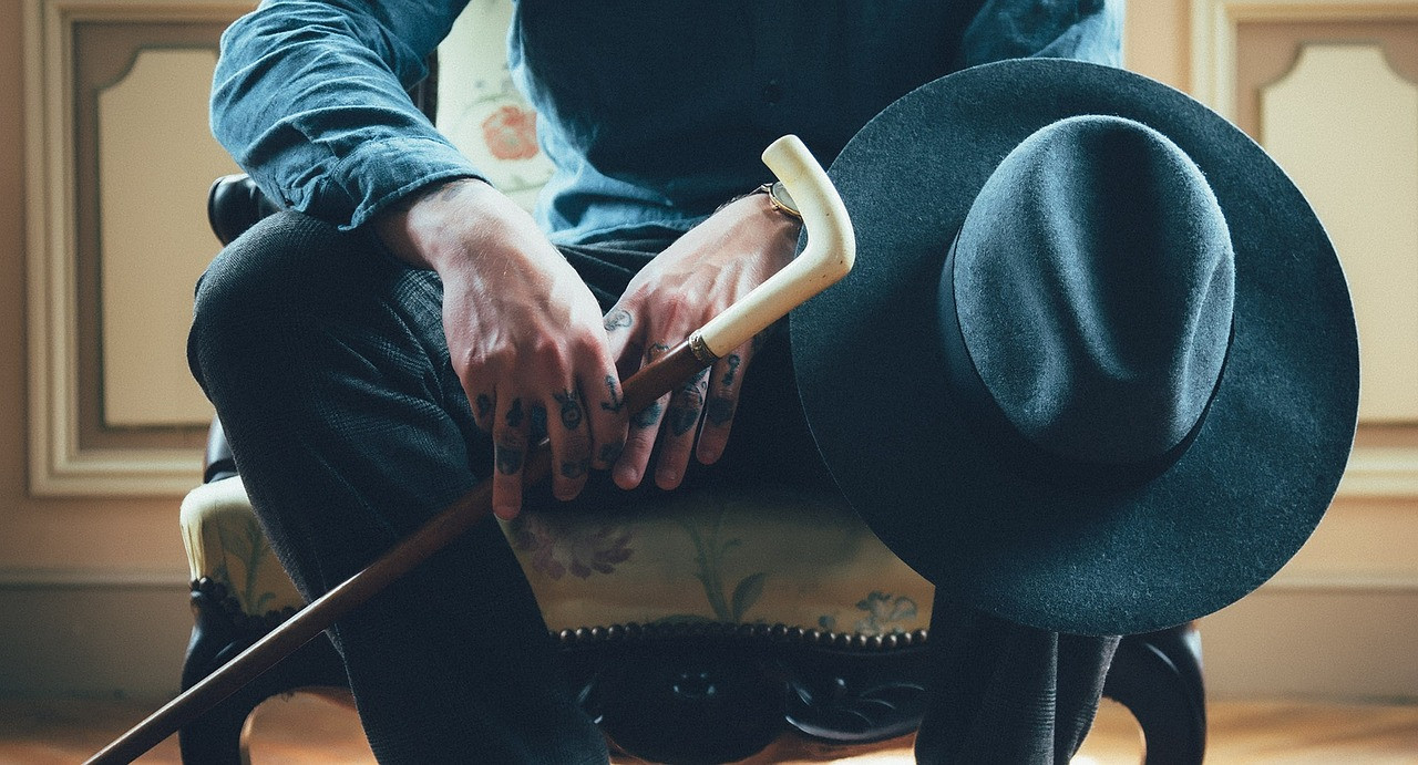 Man Sitting With Cane Old Hat White