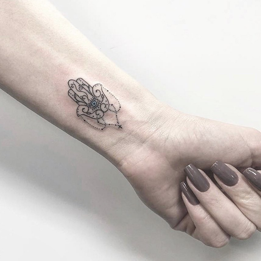 A Hamsa tattoo incorporating floral elements, blending nature with spiritual symbolism for a unique design