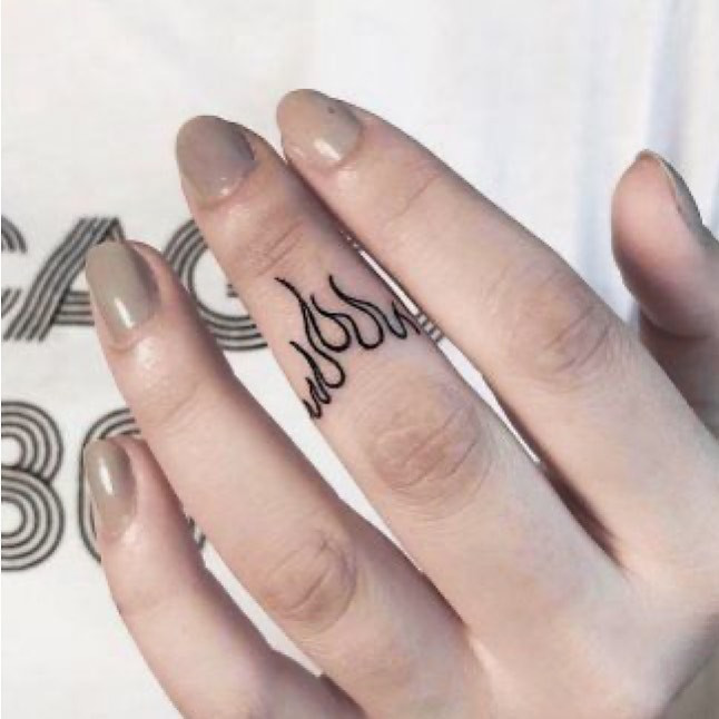 A fire finger tattoo design on a woman's finger, showcasing a fiery yet chic design.
