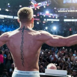 Conor McGregor back piece featuring a crucifix and helix pattern, symbolizing faith and resilience