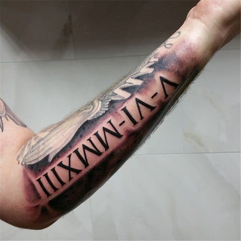 Roman numeral forearm tattoo extending along the arm like a ribbon