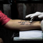 Applying Vitamin E Oil to a New Tattoo with Clean Gauze