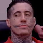 Wade Wilson with extensive face tattoos during a court appearance, showcasing white supremacist symbols