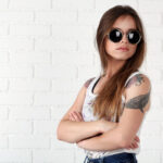 A woman showcasing a beautiful custom temporary tattoo on her shoulder, highlighting its artistic design