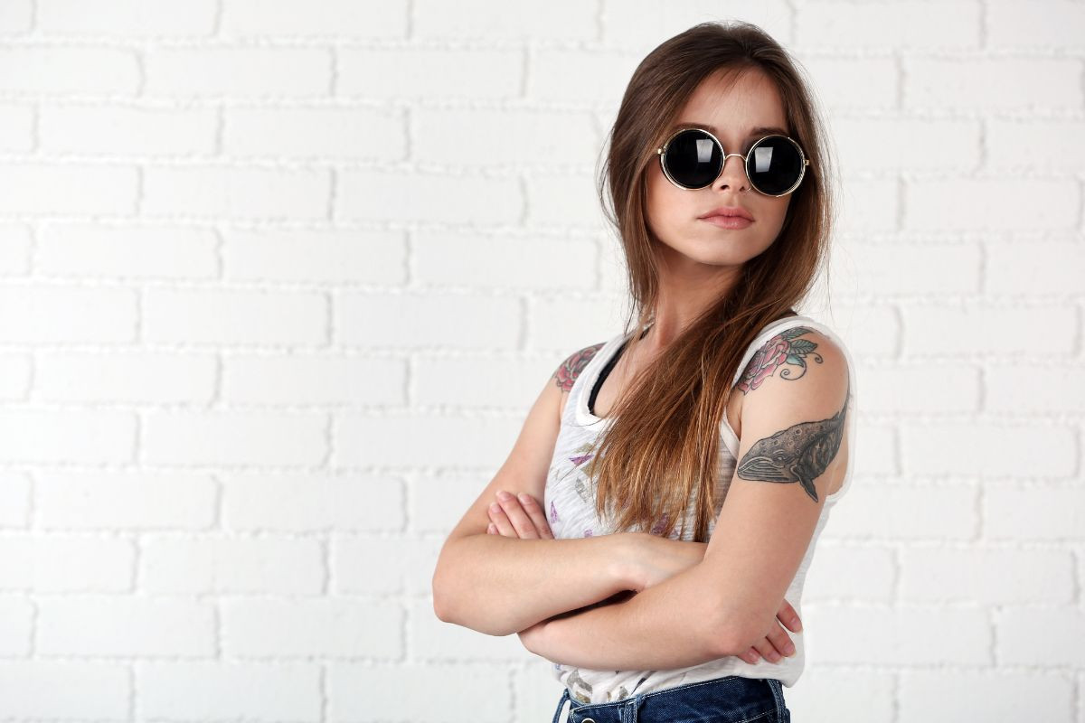 A woman showcasing a beautiful custom temporary tattoo on her shoulder, highlighting its artistic design