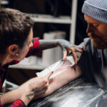 Tattoo artist carefully applying bandage