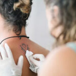 Tattoo artist carefully cleaning a new tattoo