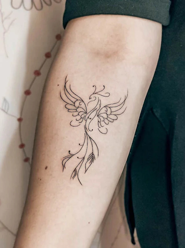 Abstract phoenix upper arm tattoo with clean outlines