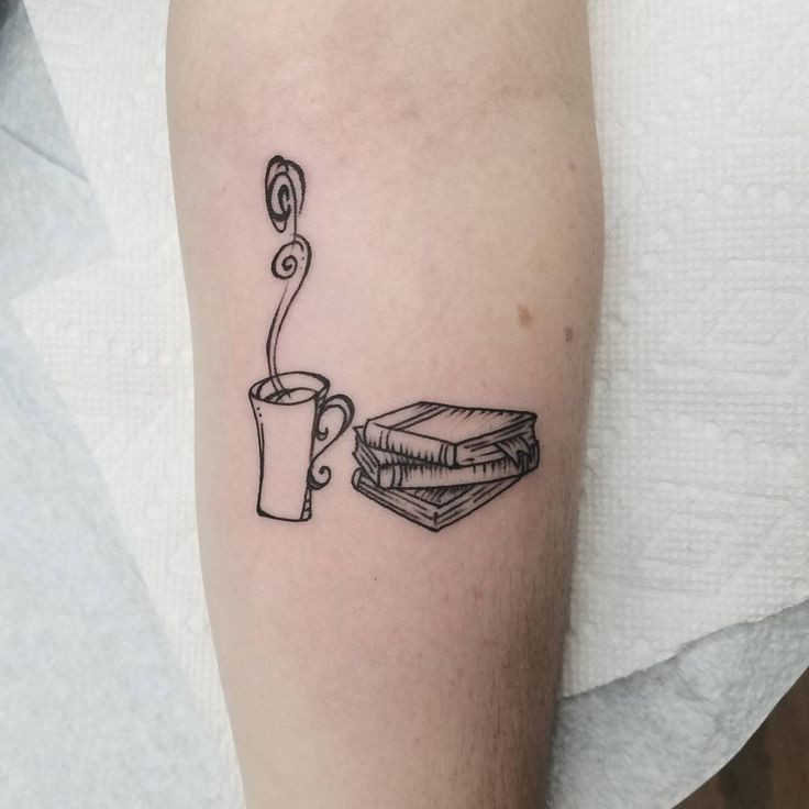 Miniature open book tattoo on wrist
