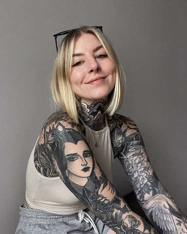 Close-up of a woman's forearm tattoo with light scabbing, showcasing the normal healing process