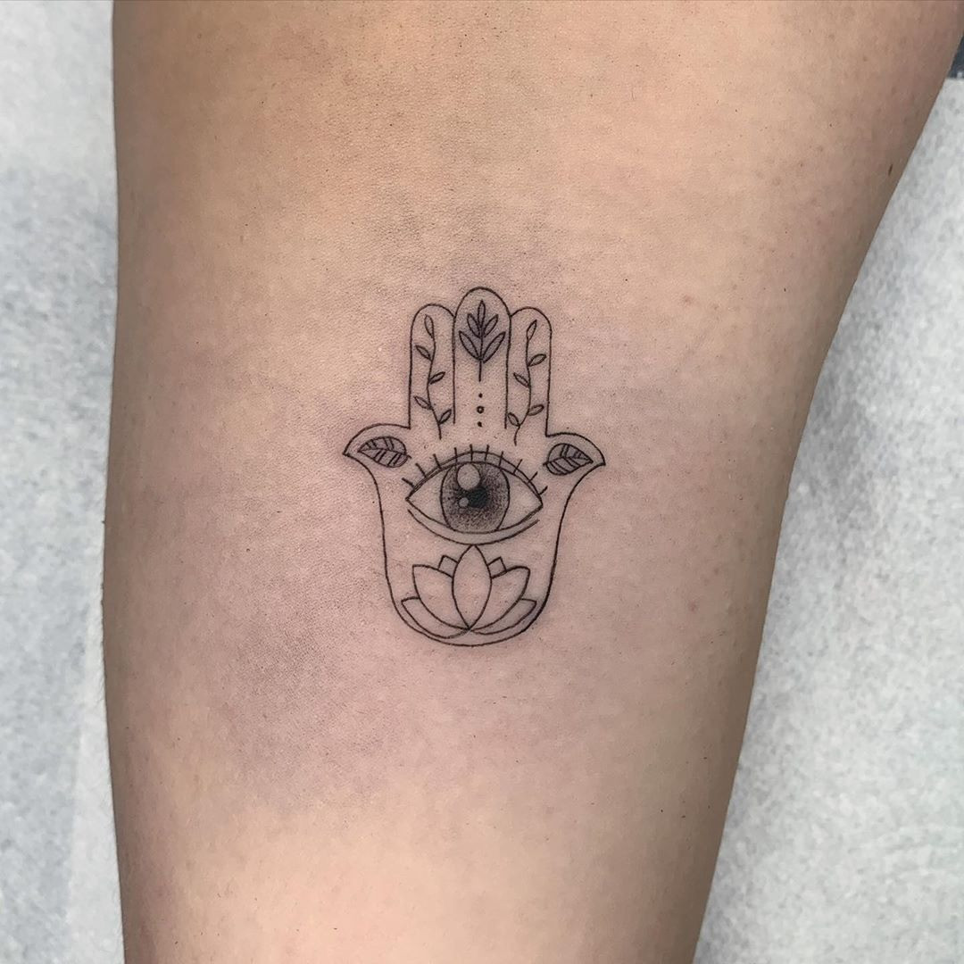 A Hamsa tattoo with fingers spread apart, signifying protection and warding off evil